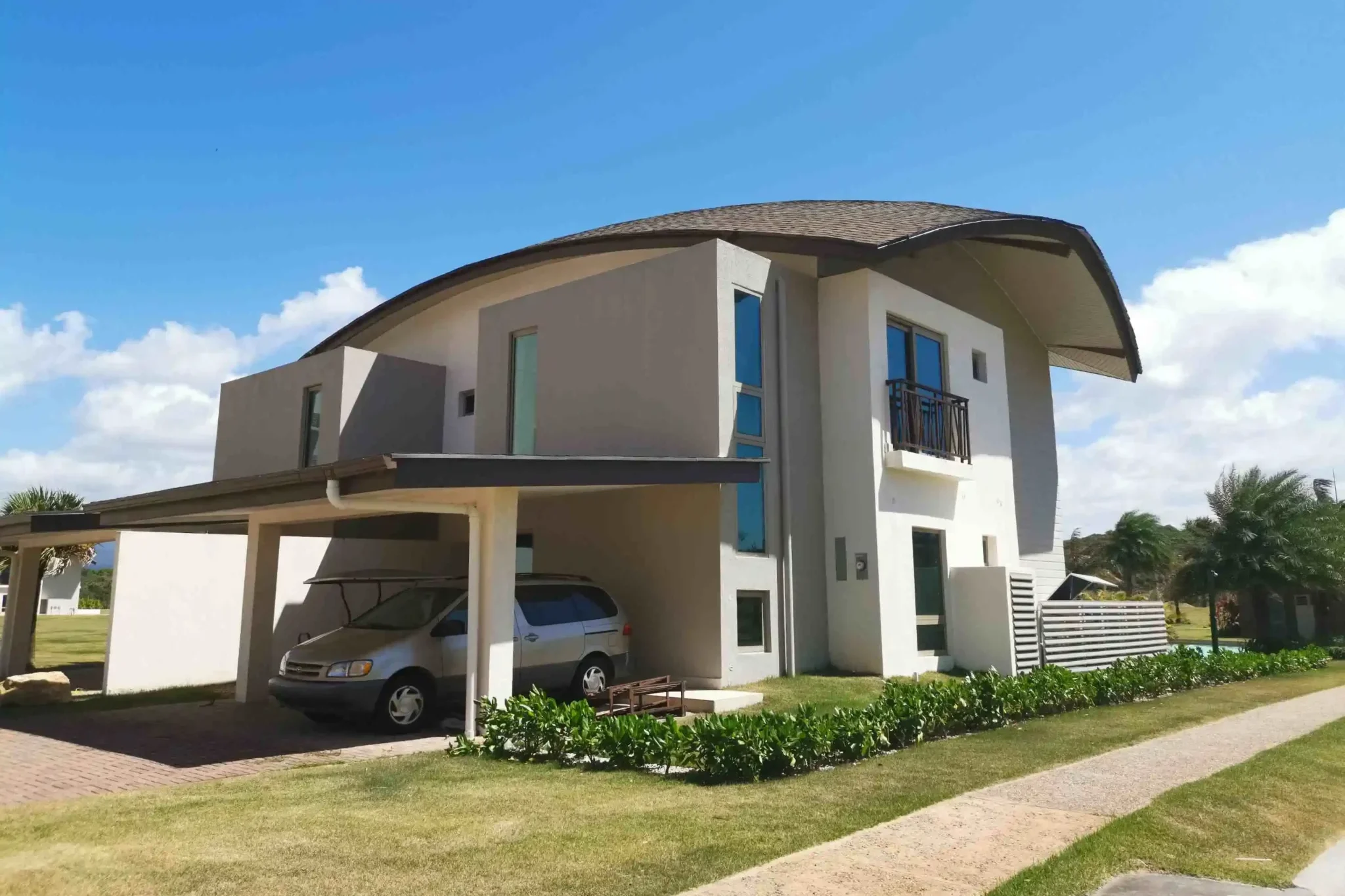 Une maison contemporaine à deux étages avec un toit incurvé