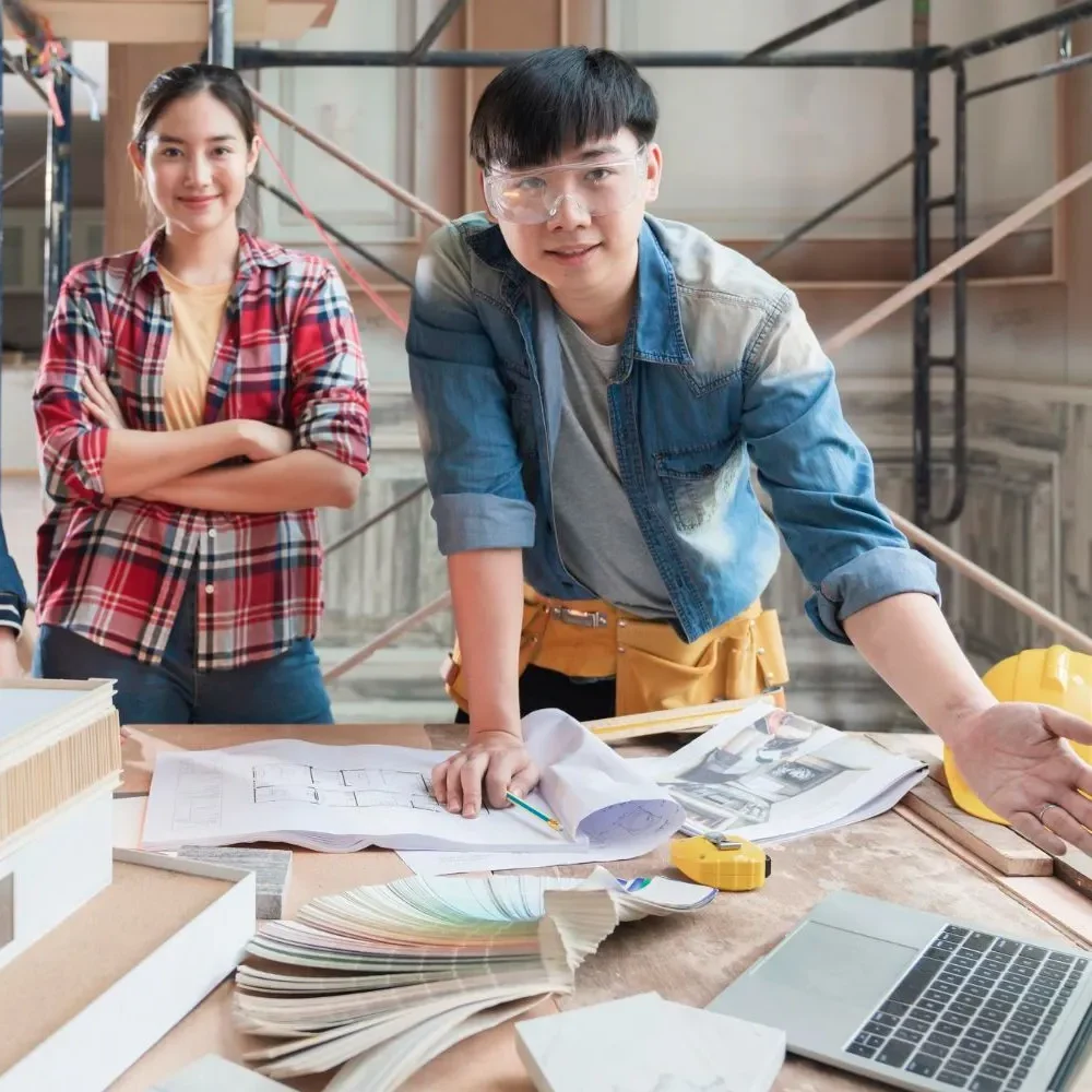 Architects discussing a building model with blueprints