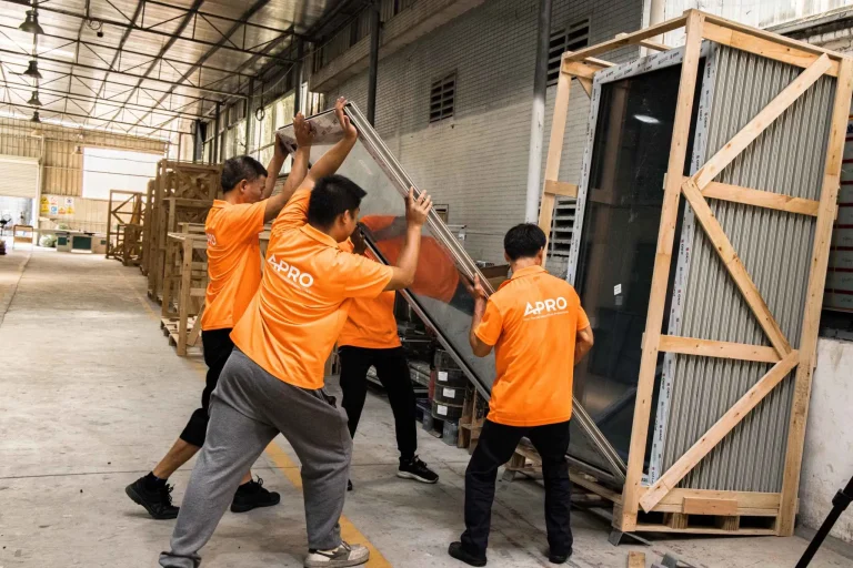 Équipe d'ouvriers soulevant de grands cadres dans l'usine