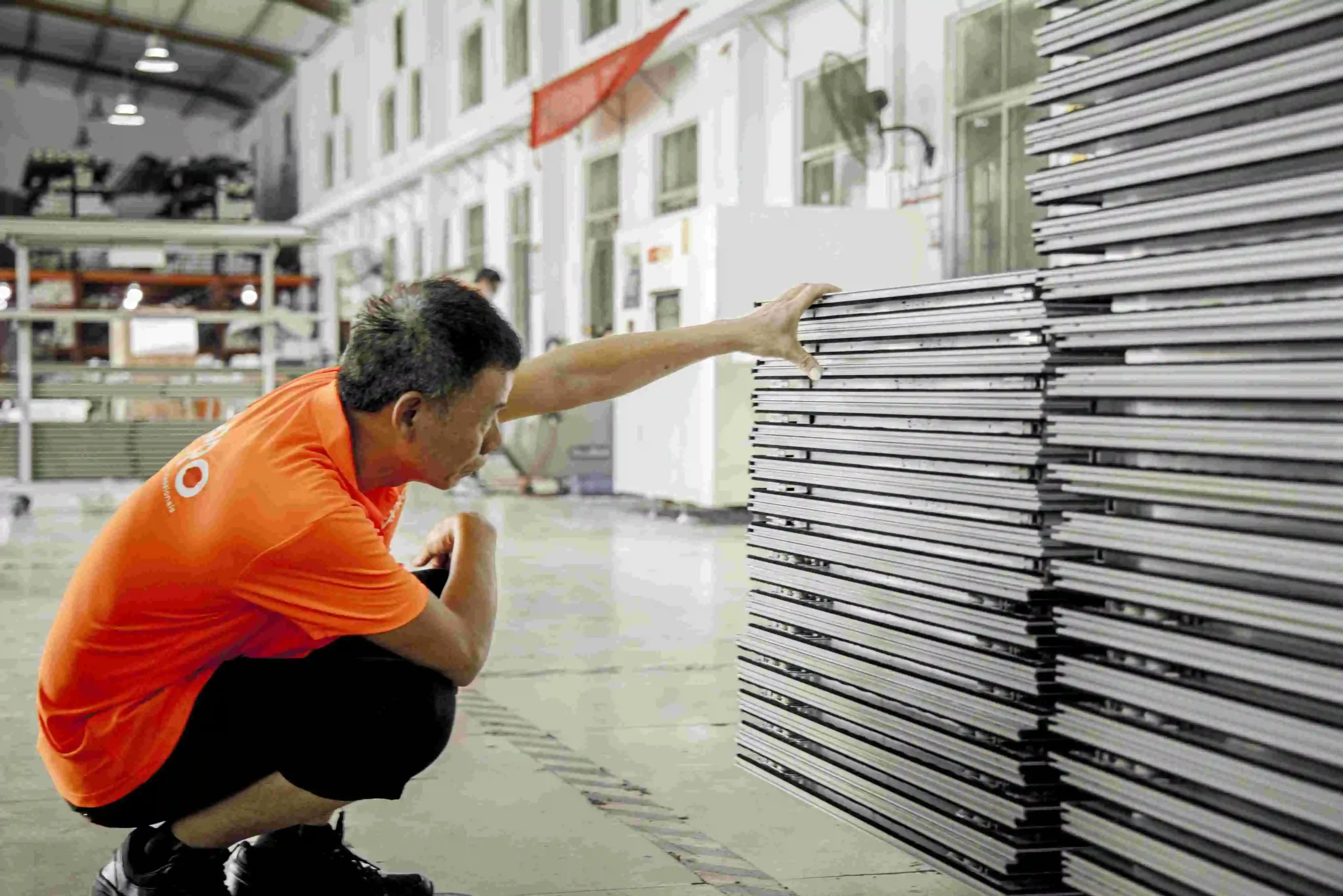 Un trabajador revisa los marcos apilados para el control de calidad.