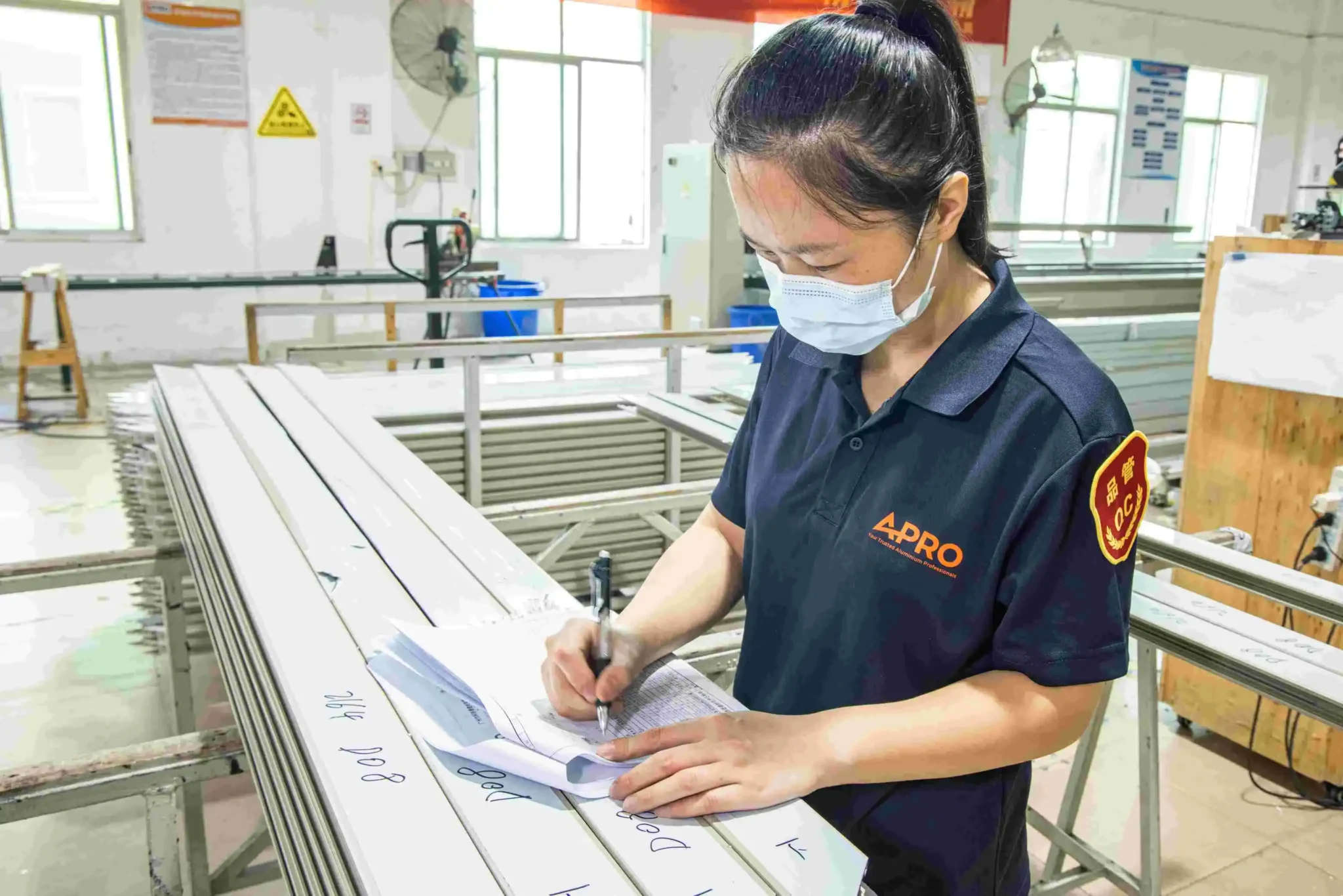 El trabajador documenta los controles de calidad de los marcos de aluminio.
