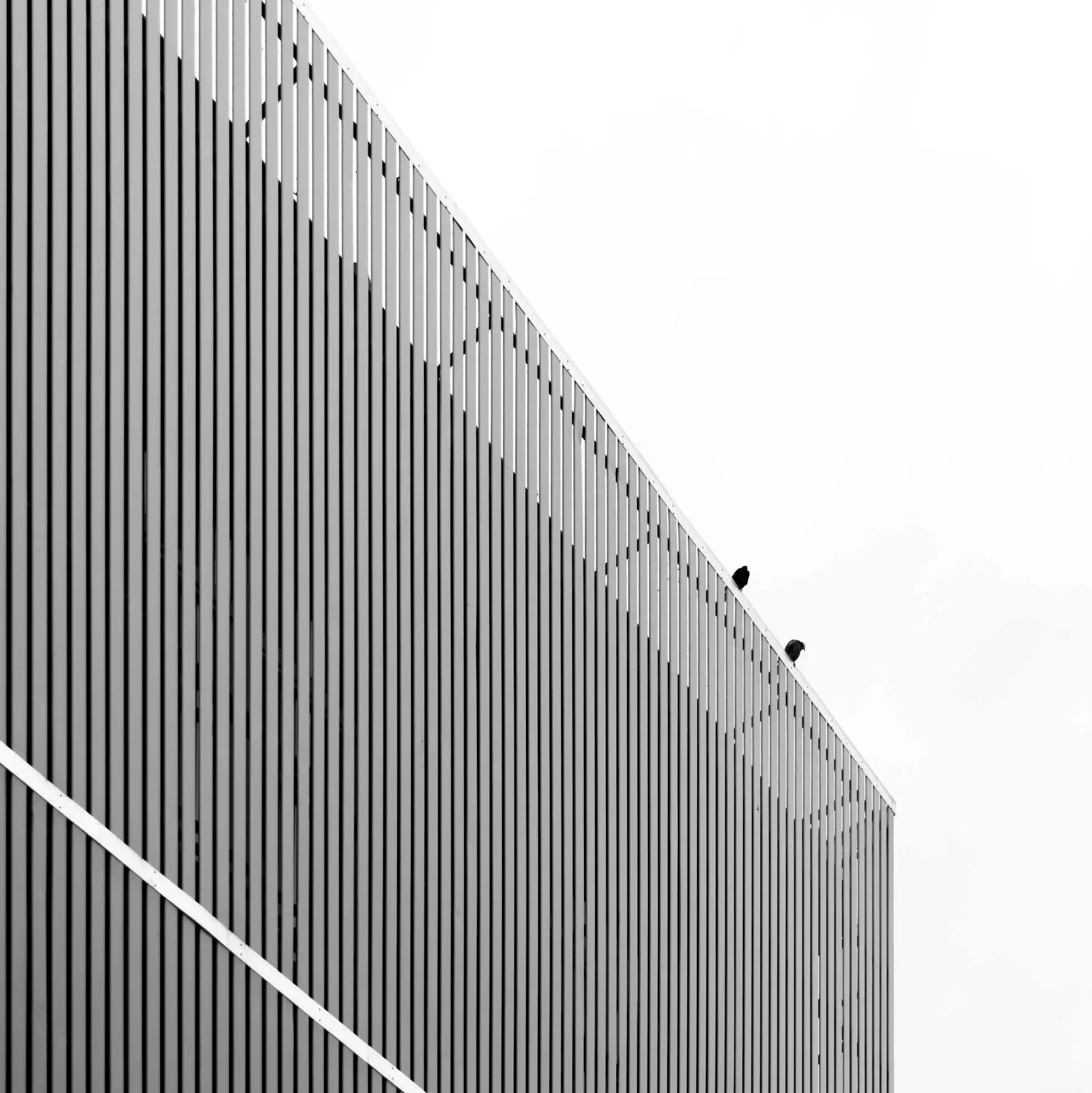 Facade with vertical louver panels and clear sky backdrop