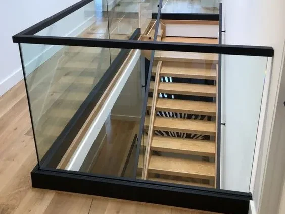 Ringhiera in vetro al secondo piano con vista sulle scale in legno