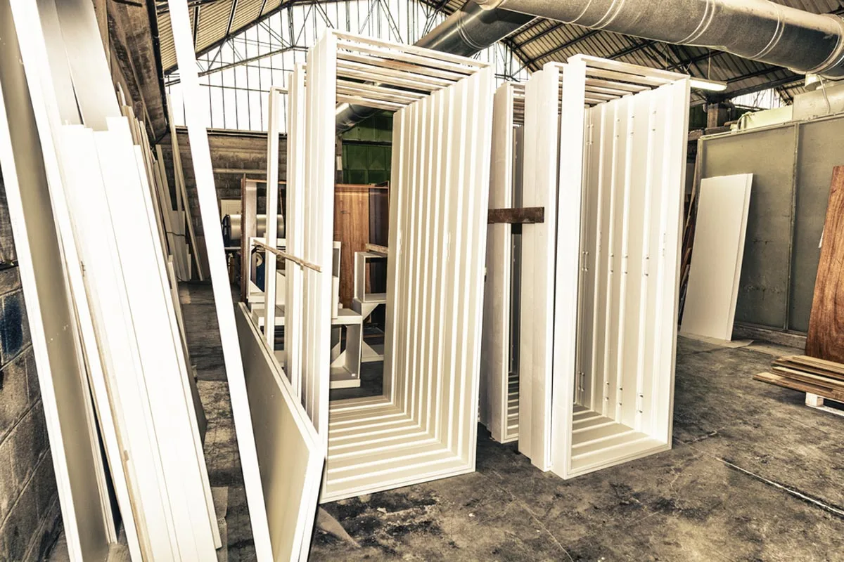 White door frames stacked in a workshop