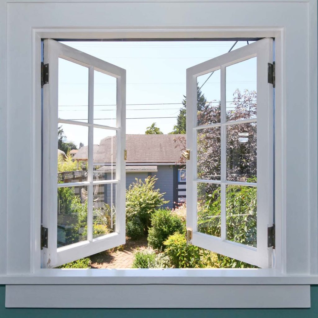 Open casement window with garden view and clear sky
