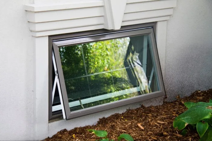 Open awning window in basement wall exterior
