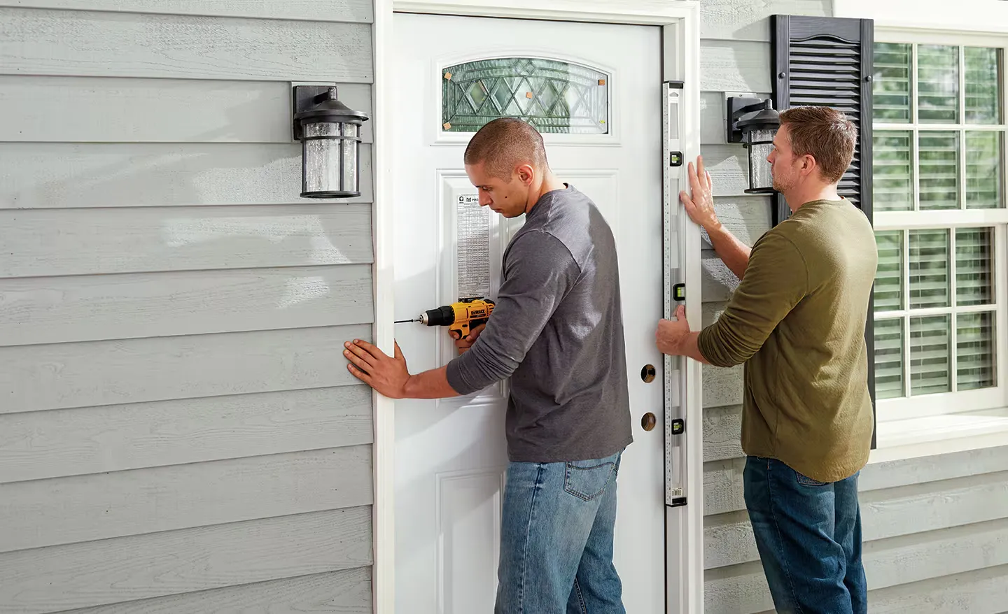 Two men replacing a front door due to ongoing small issues