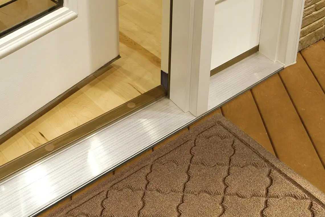 Umbral de puerta de aluminio con suelo de madera y tira de umbral