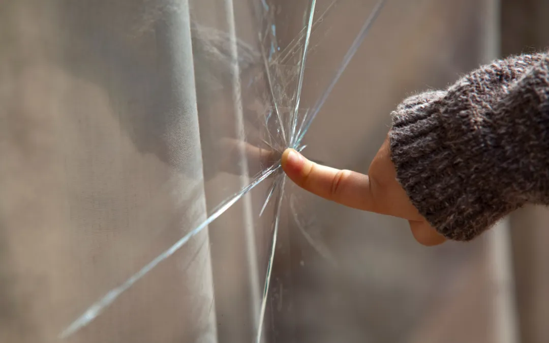 Dedo apuntando hacia el cristal roto de la puerta corrediza