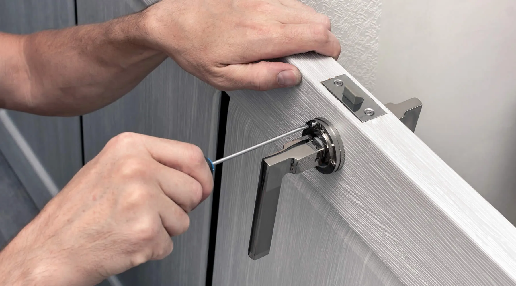 Installation de la poignée de porte avec un tournevis en gros plan