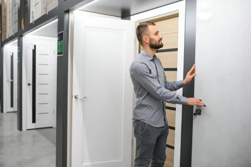 Man examining modern interior door options in a showroom