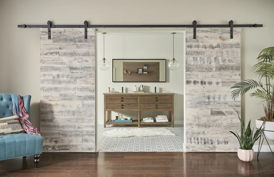 Двойные амбарные двери в деревенском стиле ведут в современную зону для умывальника
