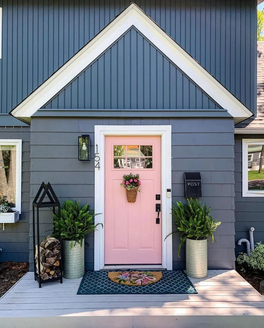Soft pink front door on blue exterior home