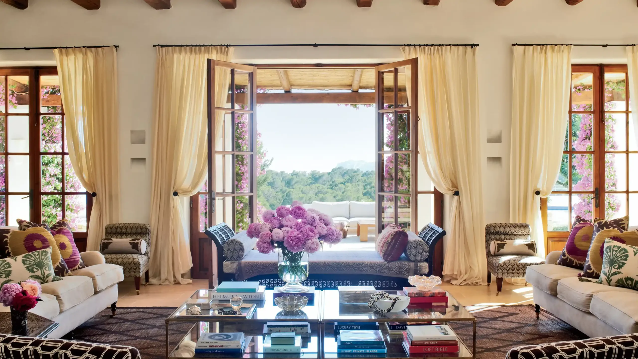 Puertas francesas de madera que se abren a una vista panorámica al aire libre.