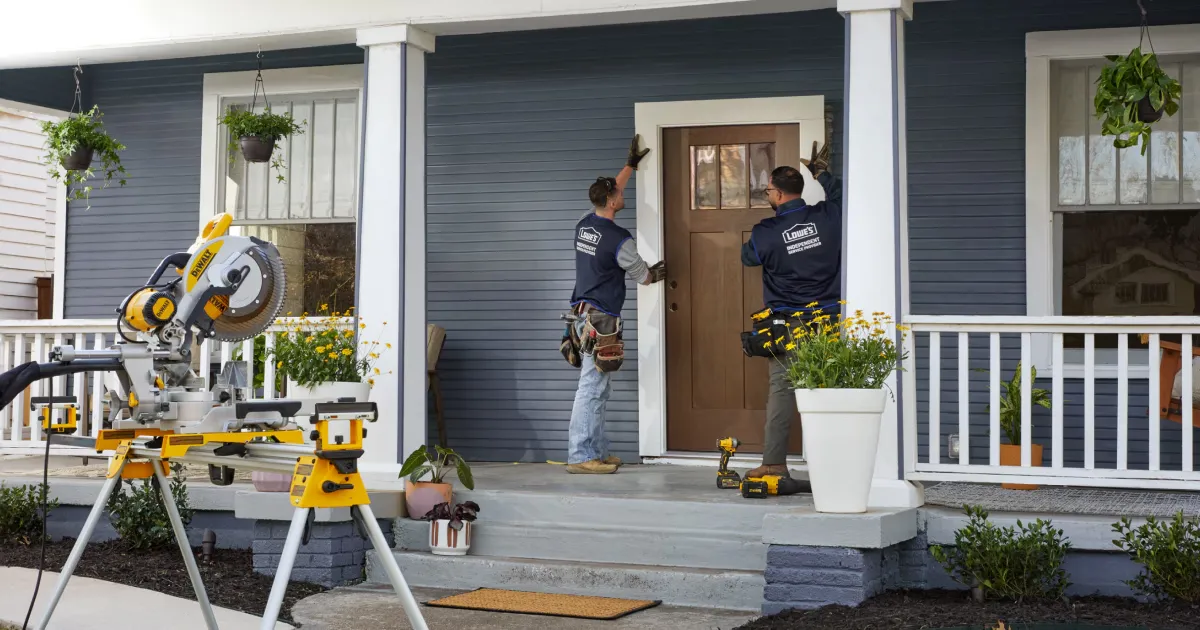 현관에 새로운 현관문을 설치하는 작업자들