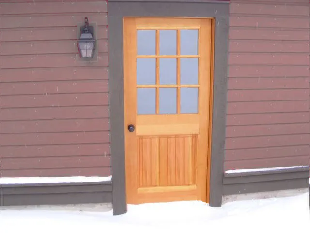 باب خارجي من خشب التنوب دوغلاس مع مدخل مغطى بالثلوج