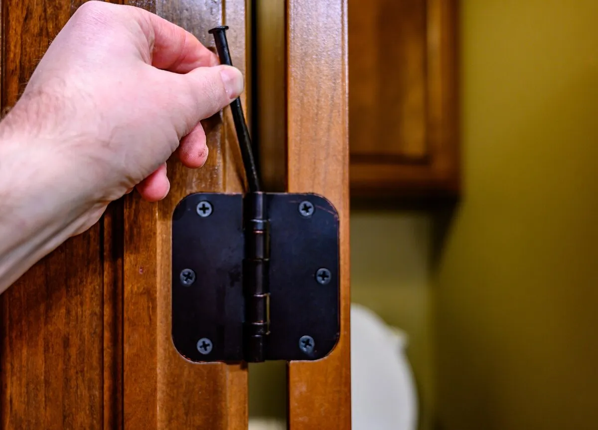ドアのヒンジからヒンジピンを引き抜く手