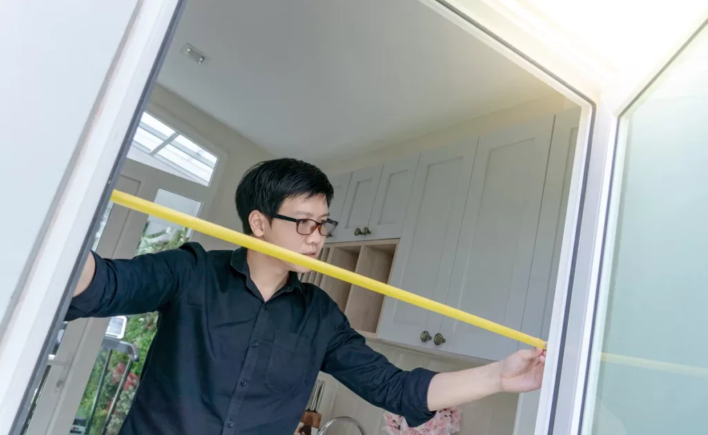 Measuring door opening with tape for weatherstrip