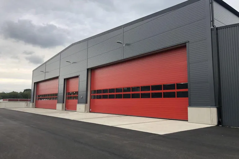 Red sectional overhead doors at large industrial warehouse