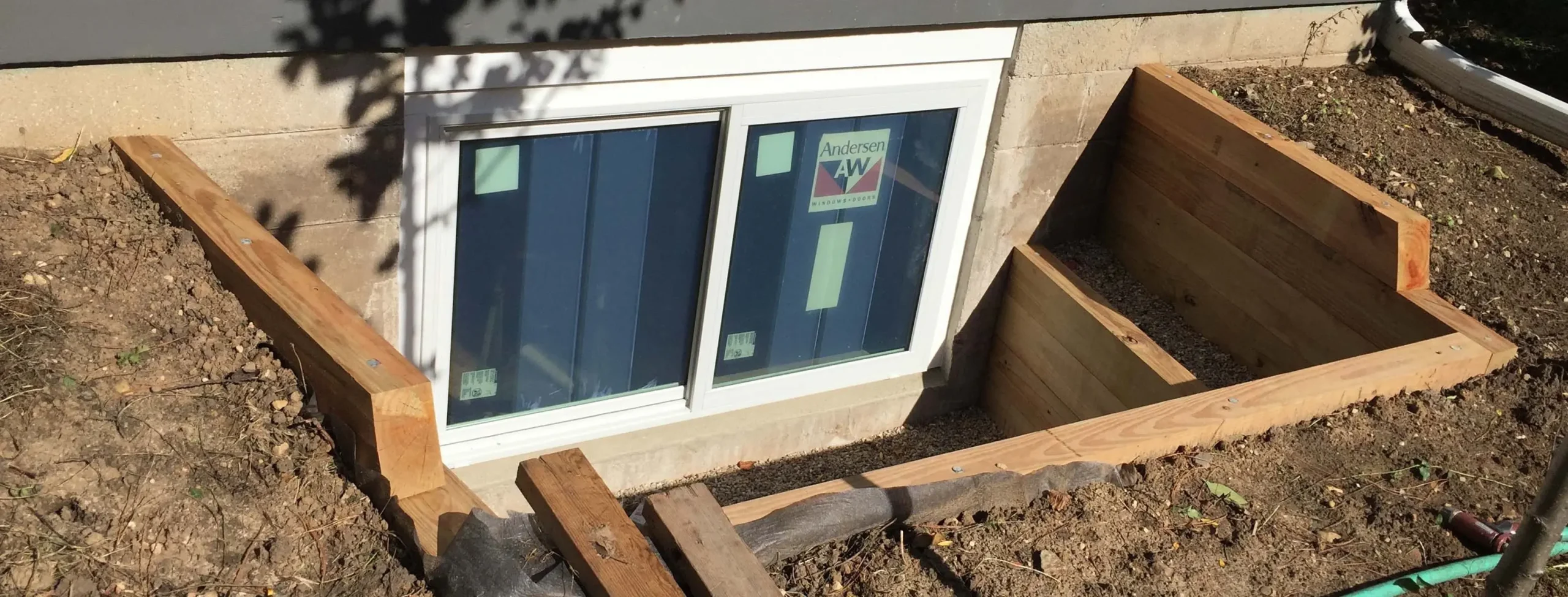 Basement egress window with wood framed window well