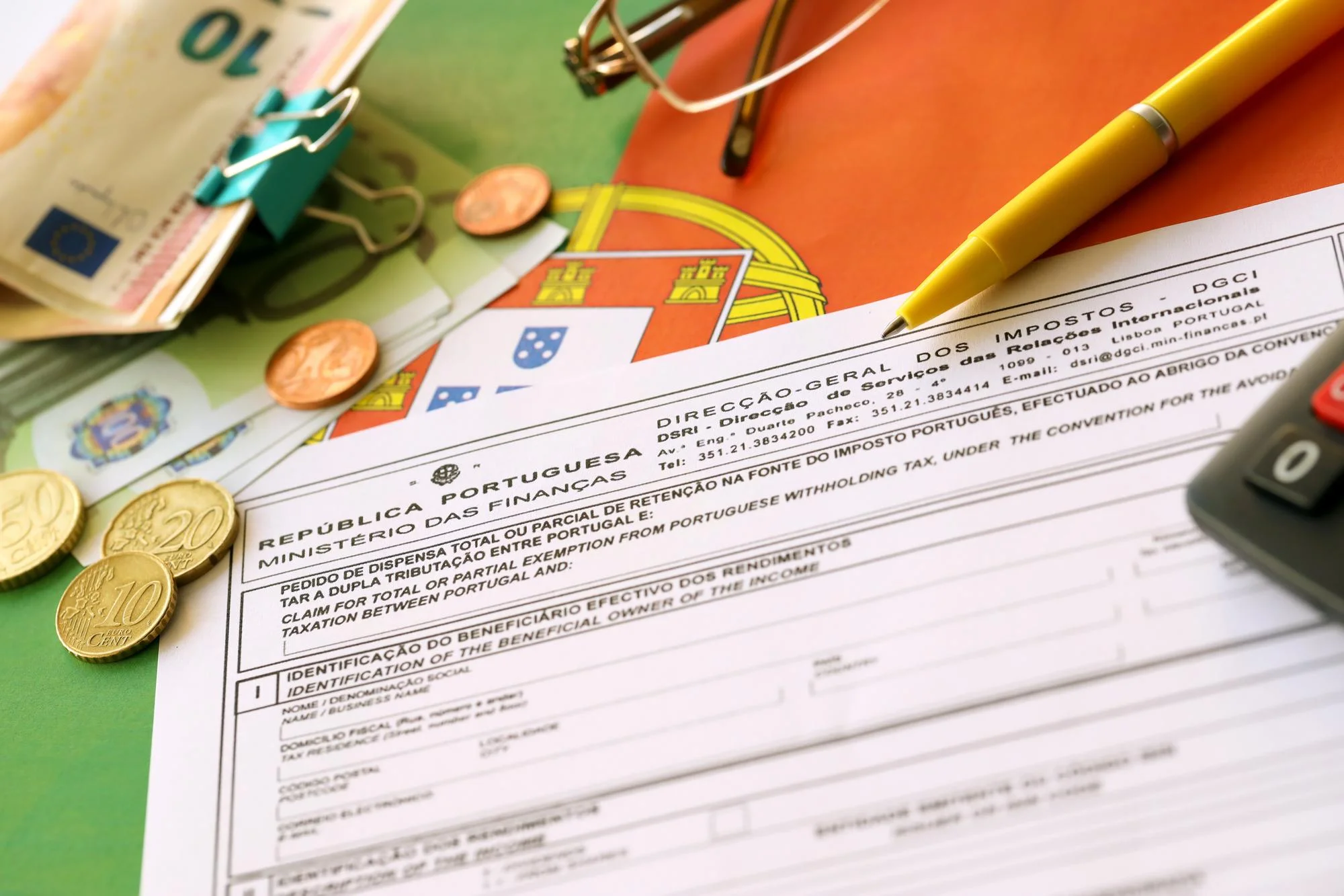 Modulo fiscale portoghese con monete in euro, banconote e penna