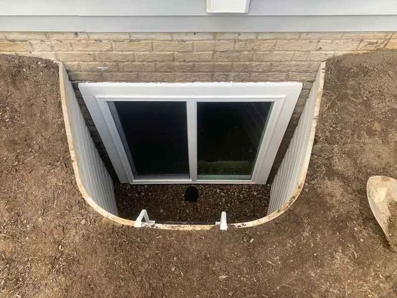 Sliding egress window with white metal well and ladder