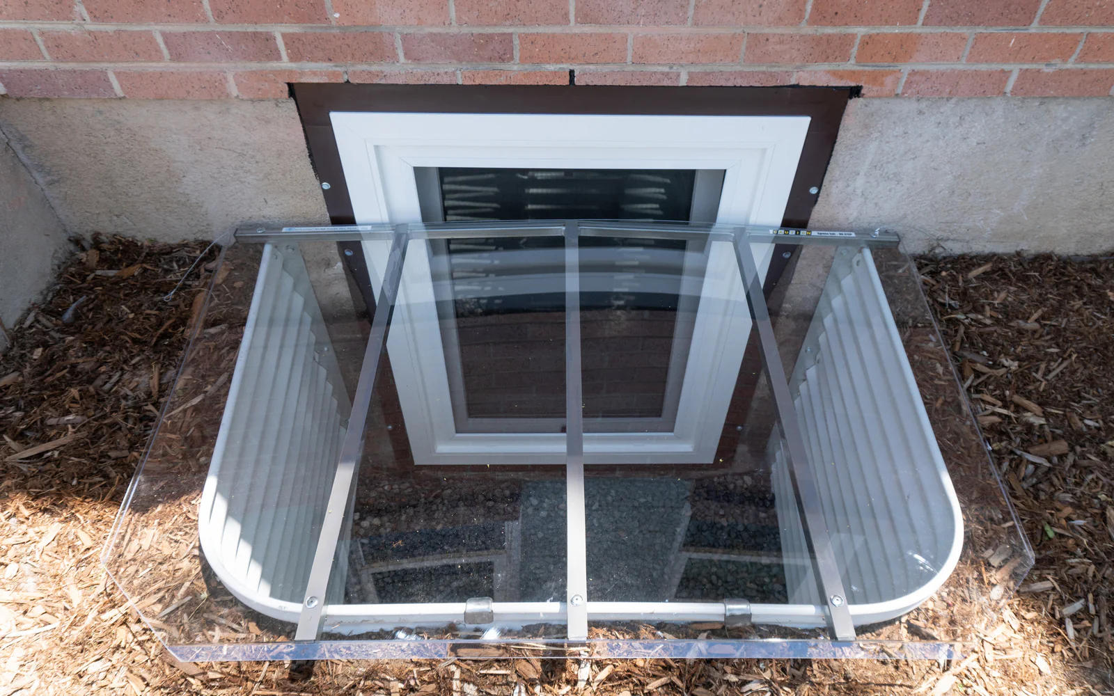 White framed egress window with clear hinged cover