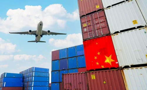 Airplane flying over stacked China export containers