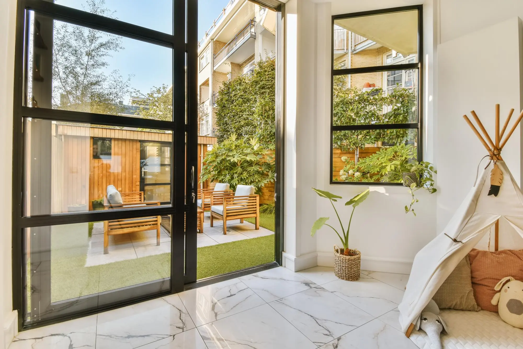 庭のパティオに面した黒枠のガラスサンルーム