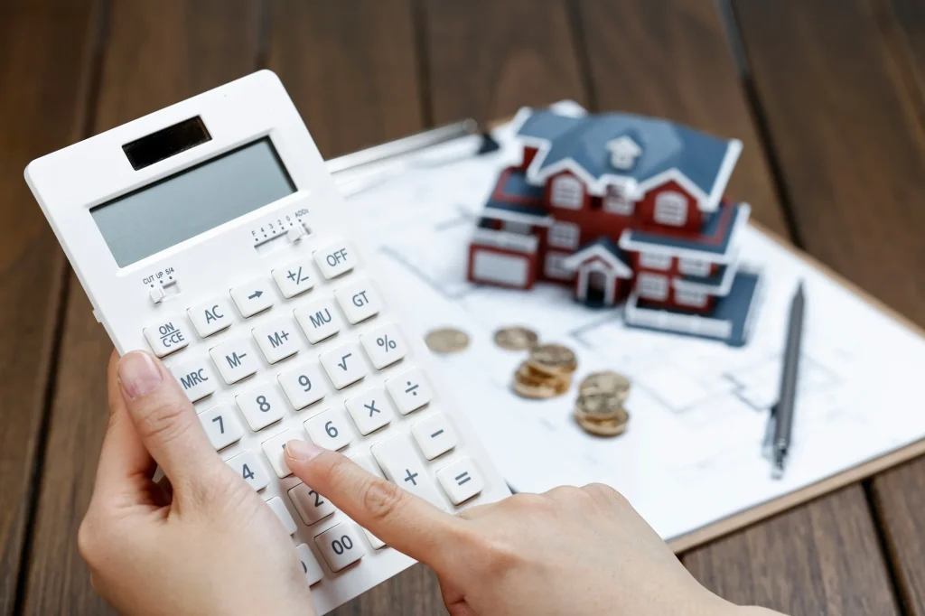 Cálculo de costes del proyecto con calculadora y modelo de vivienda