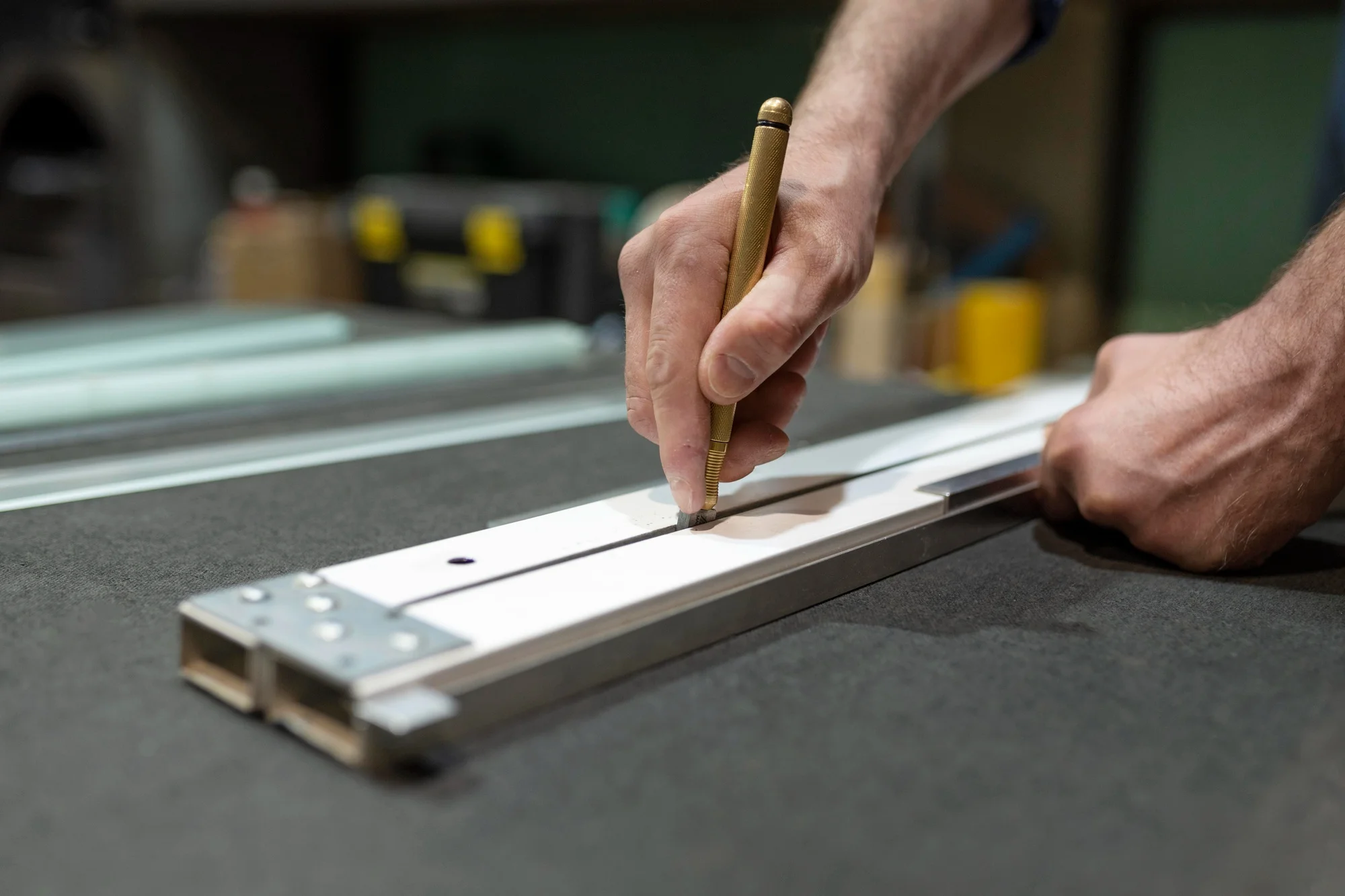 Technician marking aluminum frame for window production