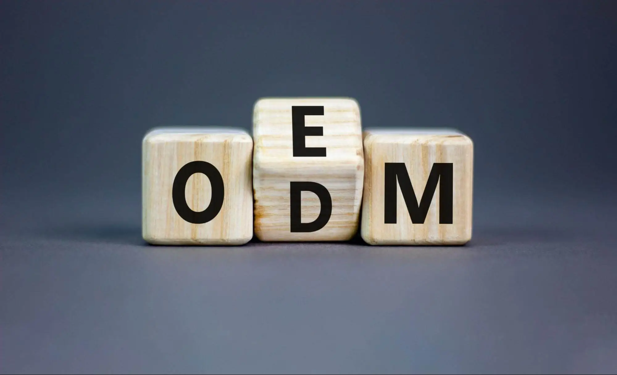 Wooden blocks showing OEM and ODM letters on a dark background