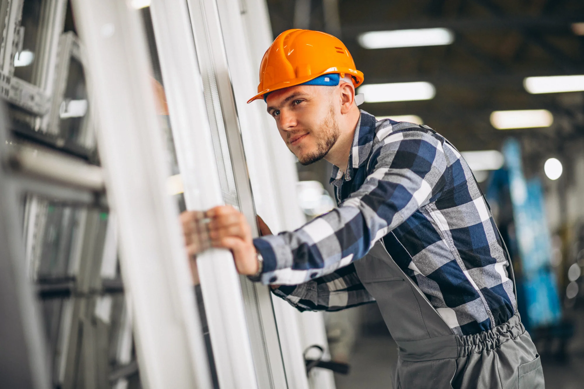 Worker inspecting window frames in manufacturing facility