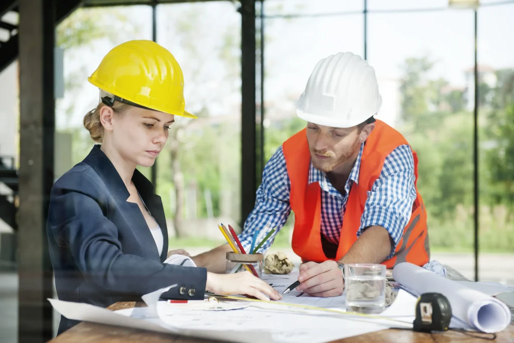 Des ingénieurs examinent les plans de construction à une table de travail.