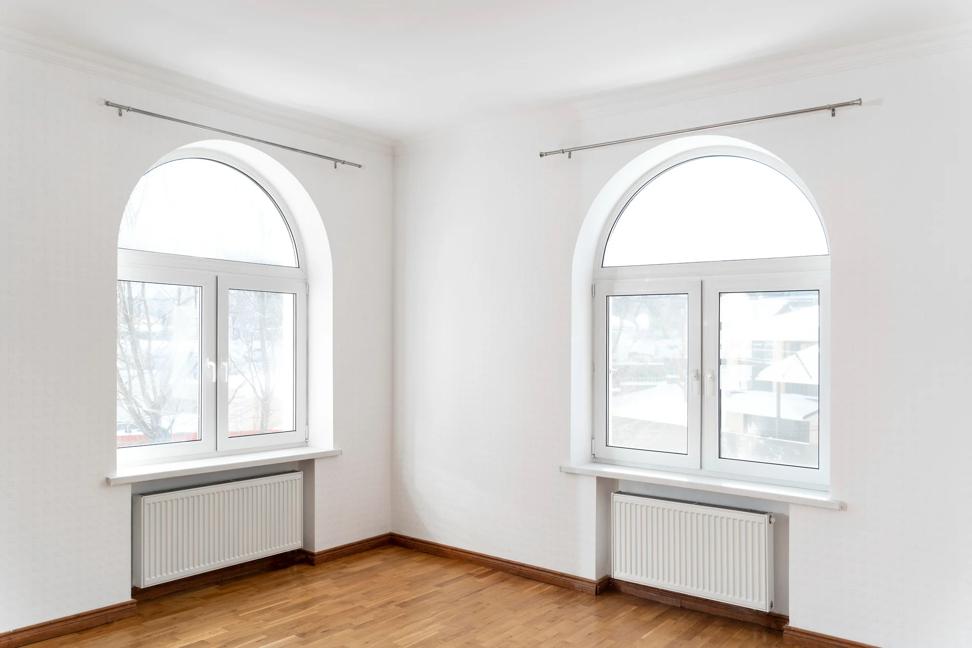 Fixed Arched Window Twin modern arched windows in bright white interior room