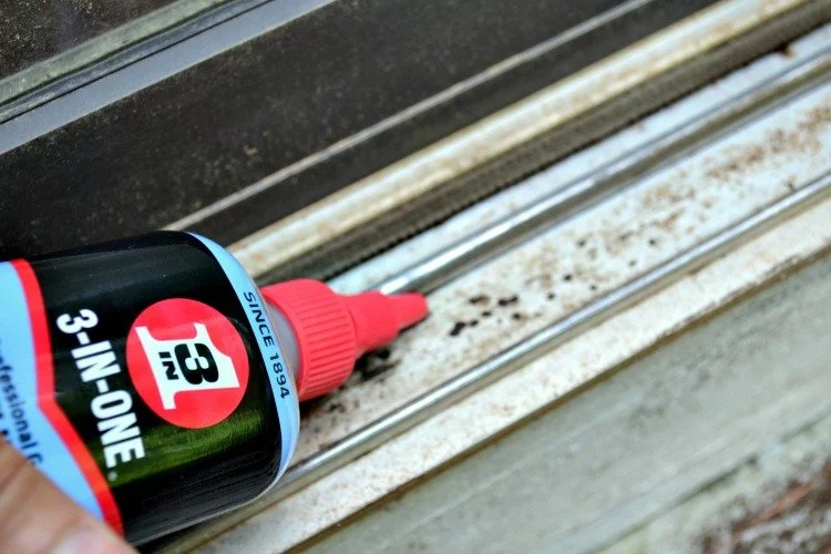 Application de lubrifiant graphite sur le rail de la porte coulissante