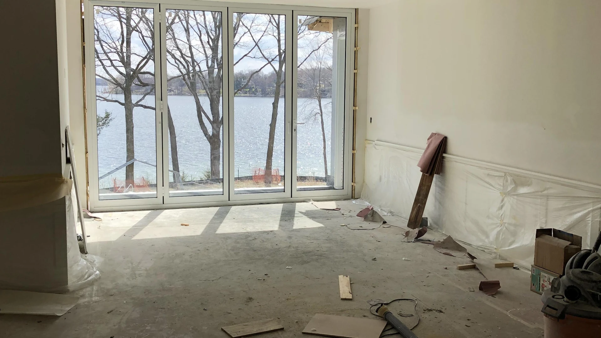Thermally broken 4-panel white aluminum folding patio doors opening to panoramic Minnesota lake views